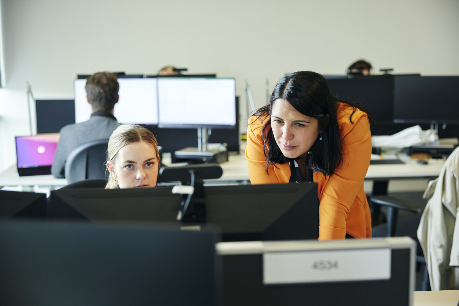 two women looking a a computer screen in an office